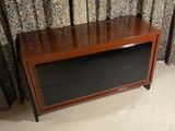 a tv that is sitting on a stand in front of a curtain