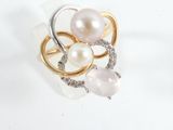 a ring with pearls and diamonds on it on a white surface
