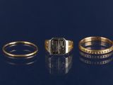 trois bagues en or et en argent, ornées de diamants, sur un fond bleu
