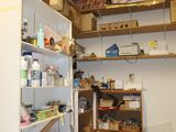 a room with a refrigerator, shelves, and other items in it