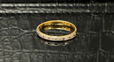 gros plan d'une bague en or sur une surface noire