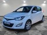 une voiture blanche est garée dans une pièce au sol à carreaux