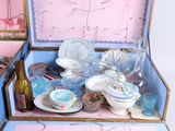 a open suitcase with a bunch of dishes inside of it