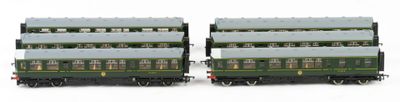 two green and white train cars sitting side by side