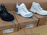 Trois paires de chaussures pour enfants se trouvent dans une boîte en carton.