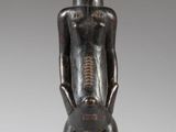 an image of a wooden statue of a man with his hands in his pockets
