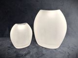 two white vases sitting next to each other on a black surface