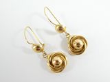 une paire de boucles d'oreilles dorées sur fond blanc