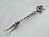 a silver spoon with a bird on it sitting on a table