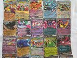 a pile of pokemon cards sitting on top of a white sheet