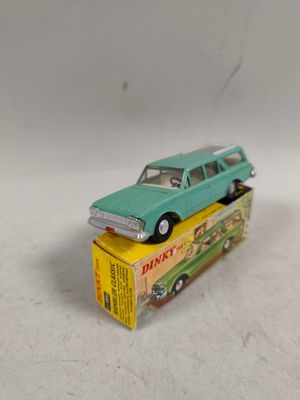 une petite voiture verte posée sur une boîte jaune