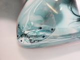 un gros plan d'un vase en verre orné d'un motif de poisson