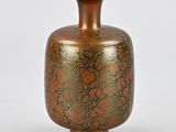 a brown vase with a gold leaf design on it