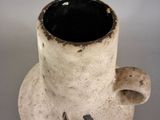 a white vase with a black and yellow design on it