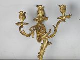 pair of antique brass wall sconces on a marble table