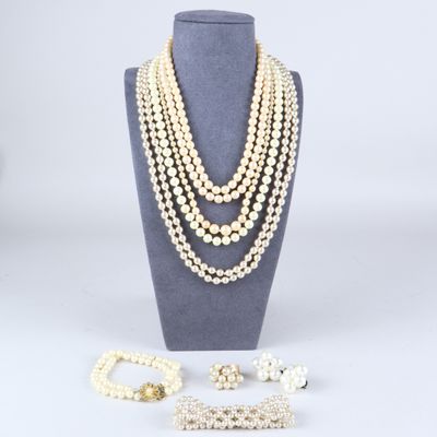 un ensemble composé d'un collier et d'un bracelet en perles blanches, présenté sur un mannequin