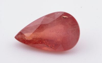 un gros plan d'un quartz rouge posé sur une surface blanche