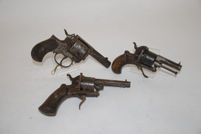 three old revolvers are sitting on a white surface