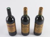 three bottles of wine sitting next to each other on a white surface