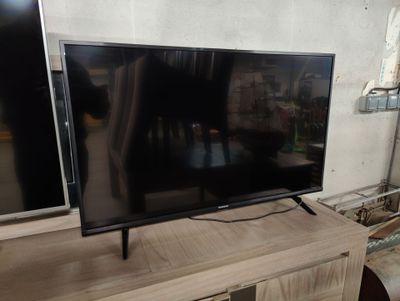 un téléviseur à écran plat posé sur un centre de divertissement en bois