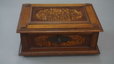 an old wooden box with carvings on it sitting on a table