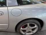 a silver car parked in a parking lot next to a parking meter