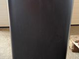 a black trash can sitting on the floor in a garage