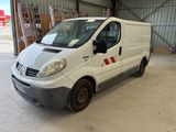 une camionnette blanche garée dans un garage, avec une bande rouge sur le côté