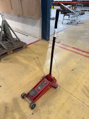 a red jack sitting on the floor next to a pile of junk