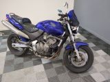 une moto bleue garée sur un sol à damier