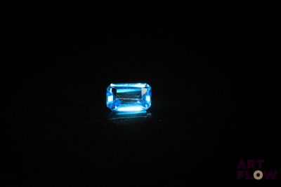 a close up of a blue stone on a black surface