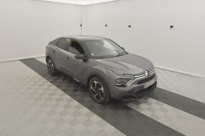 the grey car is parked in the garage on the checkered floor