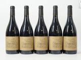 six bouteilles de vin sont alignées sur une surface blanche