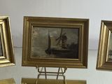 three paintings on display on a glass table