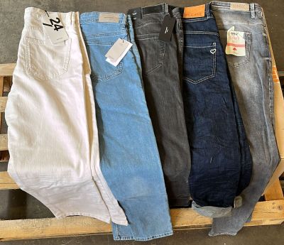 Trois paires de jeans pour homme sont posées sur une caisse en bois