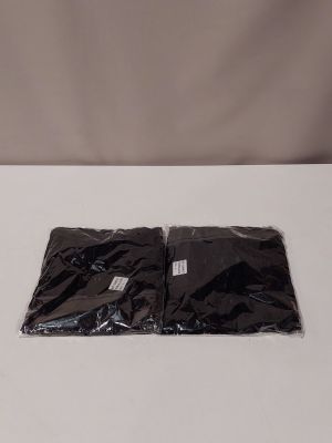 two bags of black plastic sitting on top of a white table