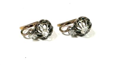 two pairs of black and white diamond earrings on a white surface