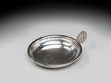 une assiette en argent posée sur une table, avec une cuillère dedans