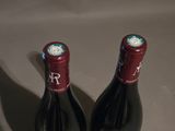 two bottles of wine sitting next to each other on a table