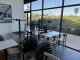 de nombreuses tables et chaises dans un restaurant donnant sur la rue