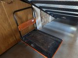 une plate-forme métallique avec un siège en bois dans un garage
