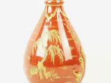 a red vase with a gold design on it
