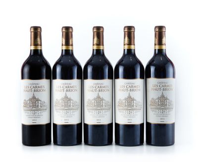 quatre bouteilles de vin sont alignées sur une surface blanche
