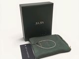 une image représentant une boîte verte contenant un collier argenté et une pochette verte