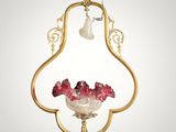 a gold and glass hanging light fixture with flowers in a vase