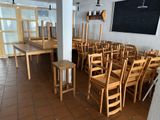 tables and chairs in a room with a chalkboard on the wall