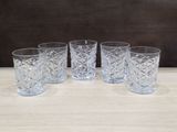 lot de quatre verres en cristal posés sur une table en bois