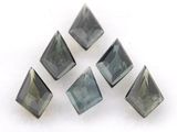 quatre morceaux de verre gris et vert sur une surface blanche