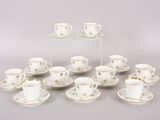 six tasses et soucoupes ornées d'étoiles dorées sont posées sur une table