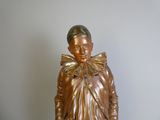 a bronze statue of a boy with a bow on his head
